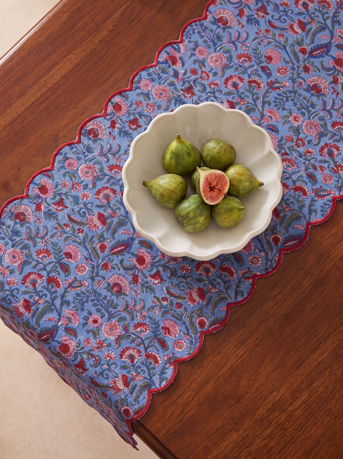 Detail of Berry Meadow pink red and green floral block print on blue quilted cotton