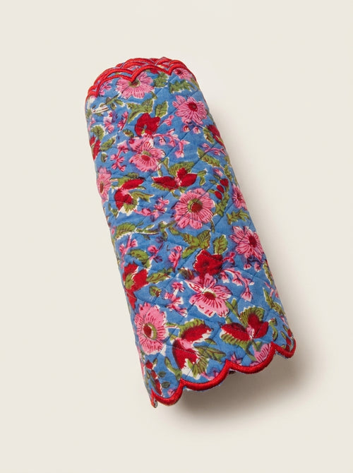 Berry Meadow quilted cotton table runner folded with pink and red floral print and red scalloped edging