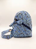 Fabalore Blue Bloom quilted sling backpack with blue floral print, front zip pocket and adjustable strap.