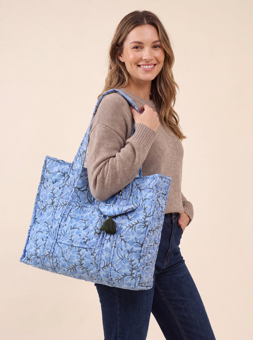 Woman carrying the Blue Bloom quilted cotton tote bag over her shoulder