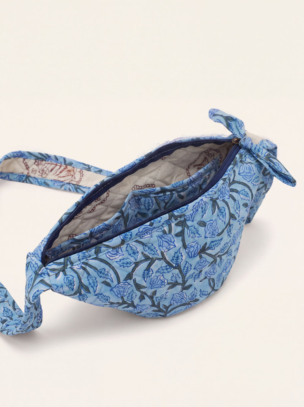 Open Fabalore Blue Bloom quilted sling bag showing zip closure, lined interior and inner pocket.