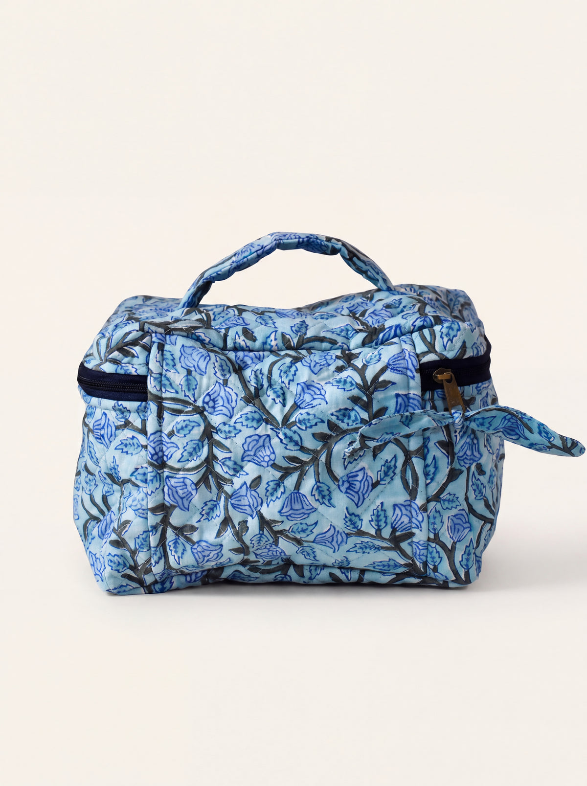 Fabalore Blue Bloom quilted toiletry case with blue floral vine print and top carry handle.