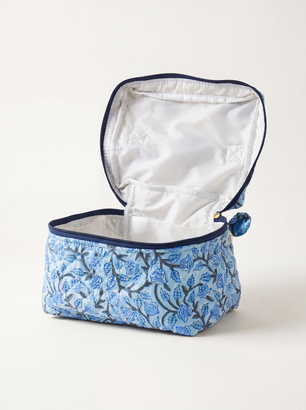Open Fabalore Blue Bloom quilted vanity case showing lined interior and organizational pockets.