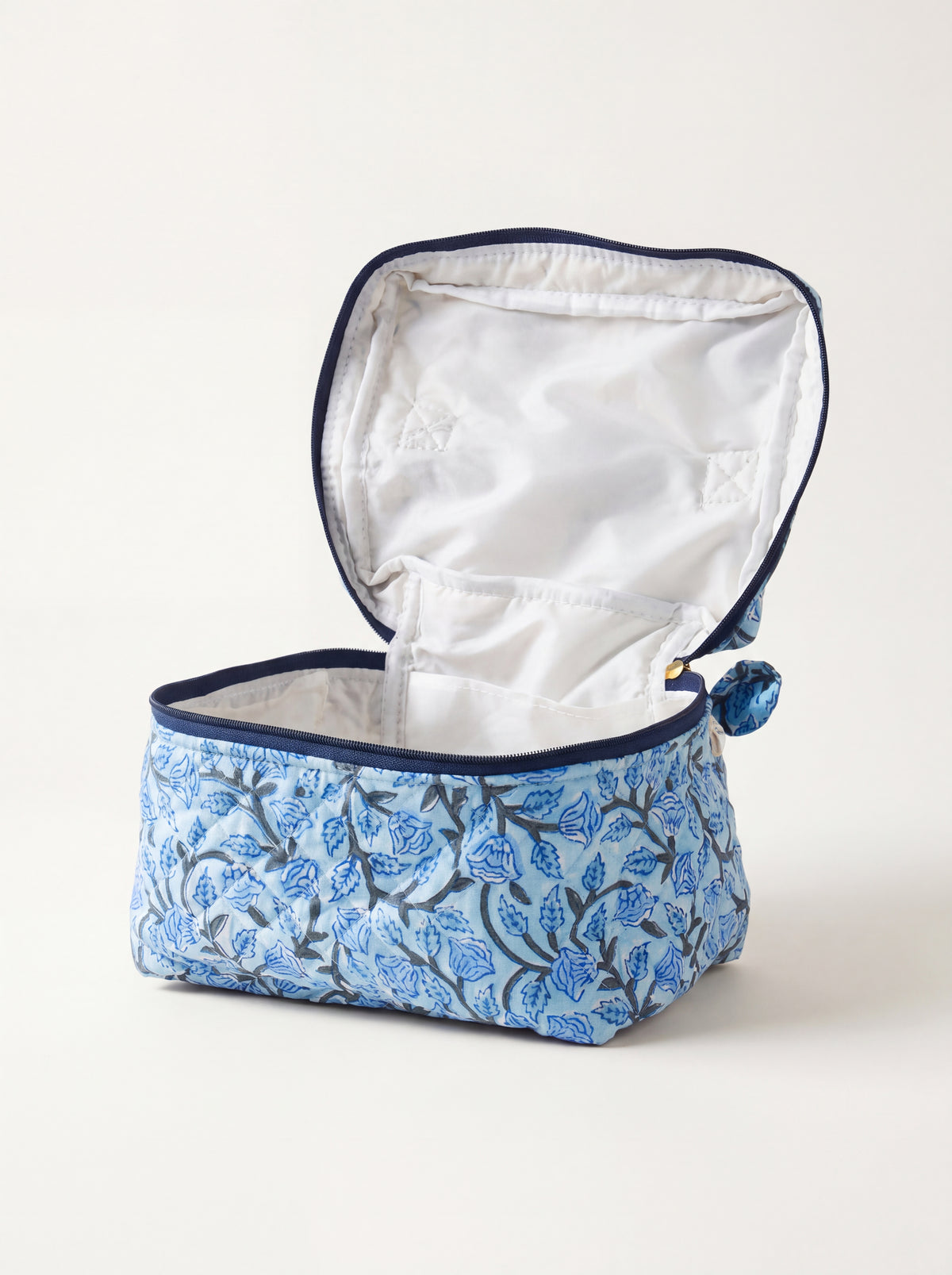 Open Fabalore Blue Bloom quilted vanity case showing lined interior and organizational pockets.