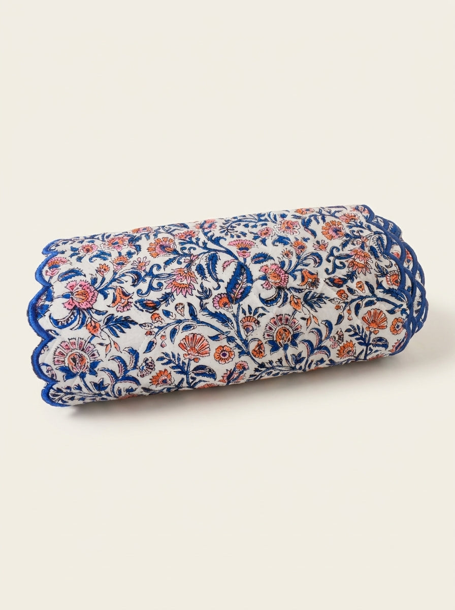Coral Garden quilted cotton table runner folded to show blue scalloped edging and coral floral block print