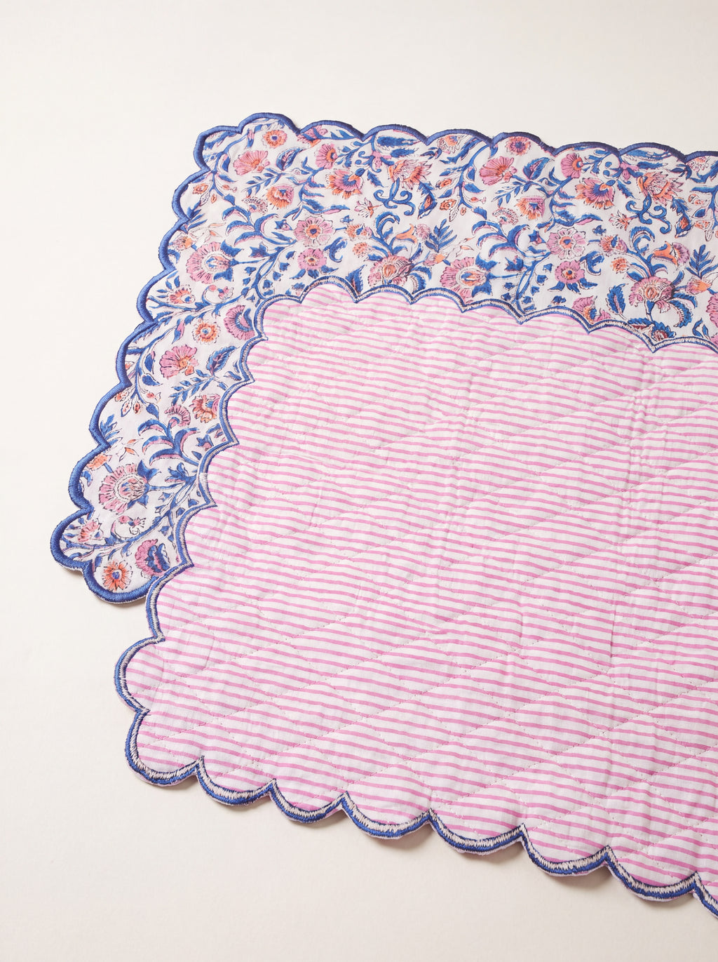 Reverse side of Coral Garden quilted table runner showing pink striped cotton backing and scalloped edge