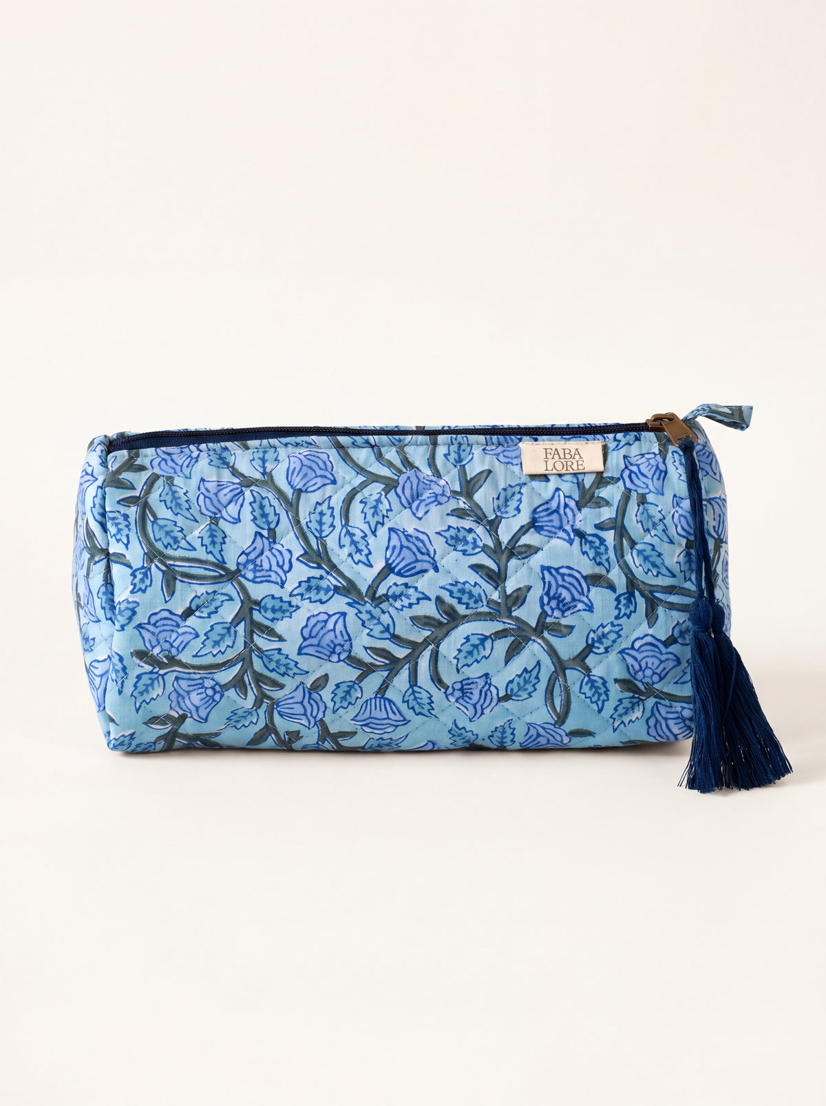 Medium Fabalore Indigo Bloom quilted floral pouch with navy zipper and tassel.