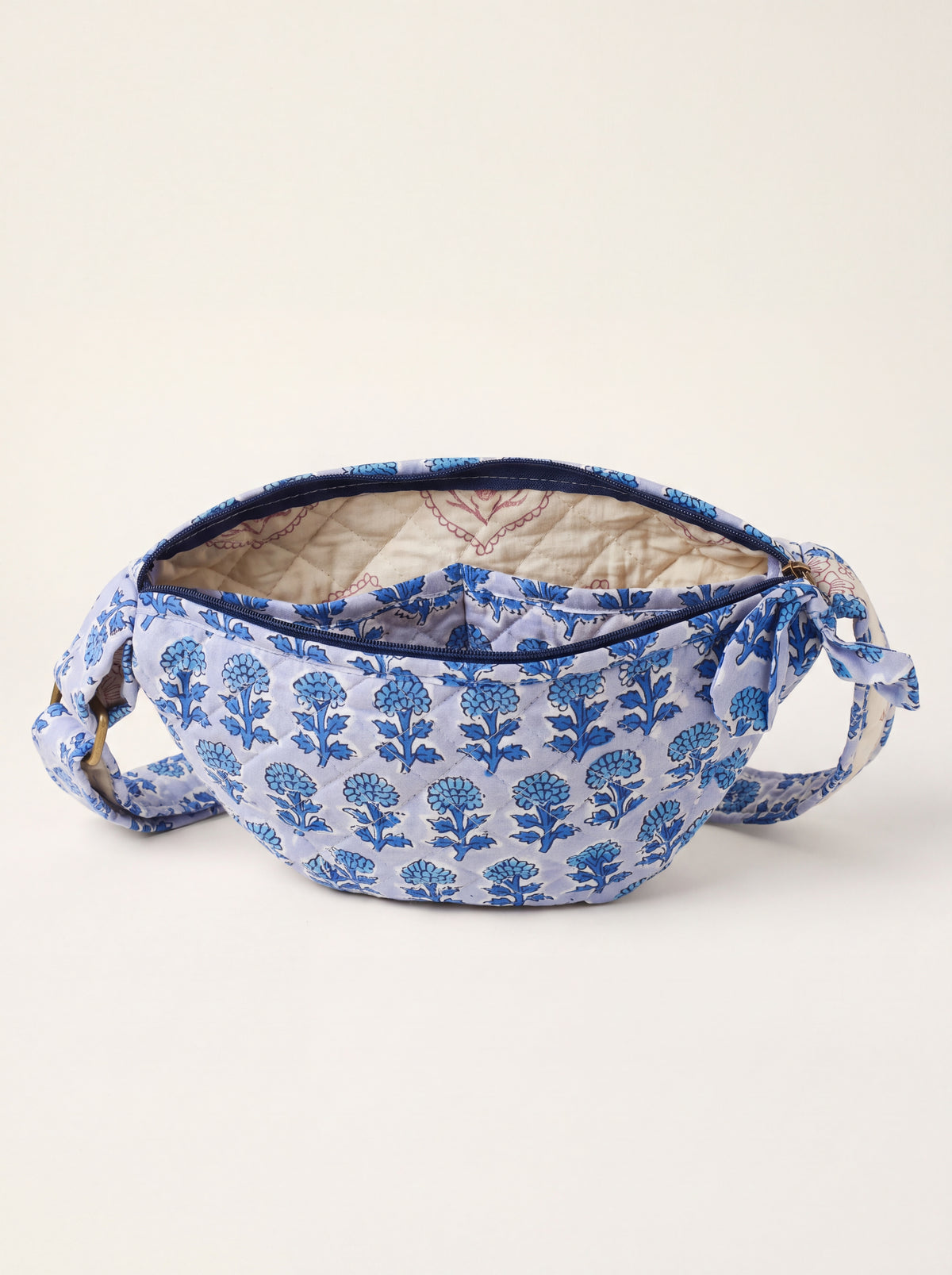 Open Fabalore Indigo Bloom quilted sling bag showing zip closure, lined interior and inner pocket.