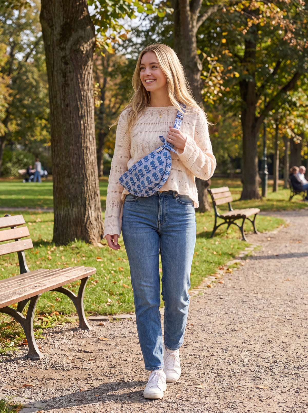 Woman wearing the Fabalore Indigo Bloom quilted floral sling bag crossbody outdoors.