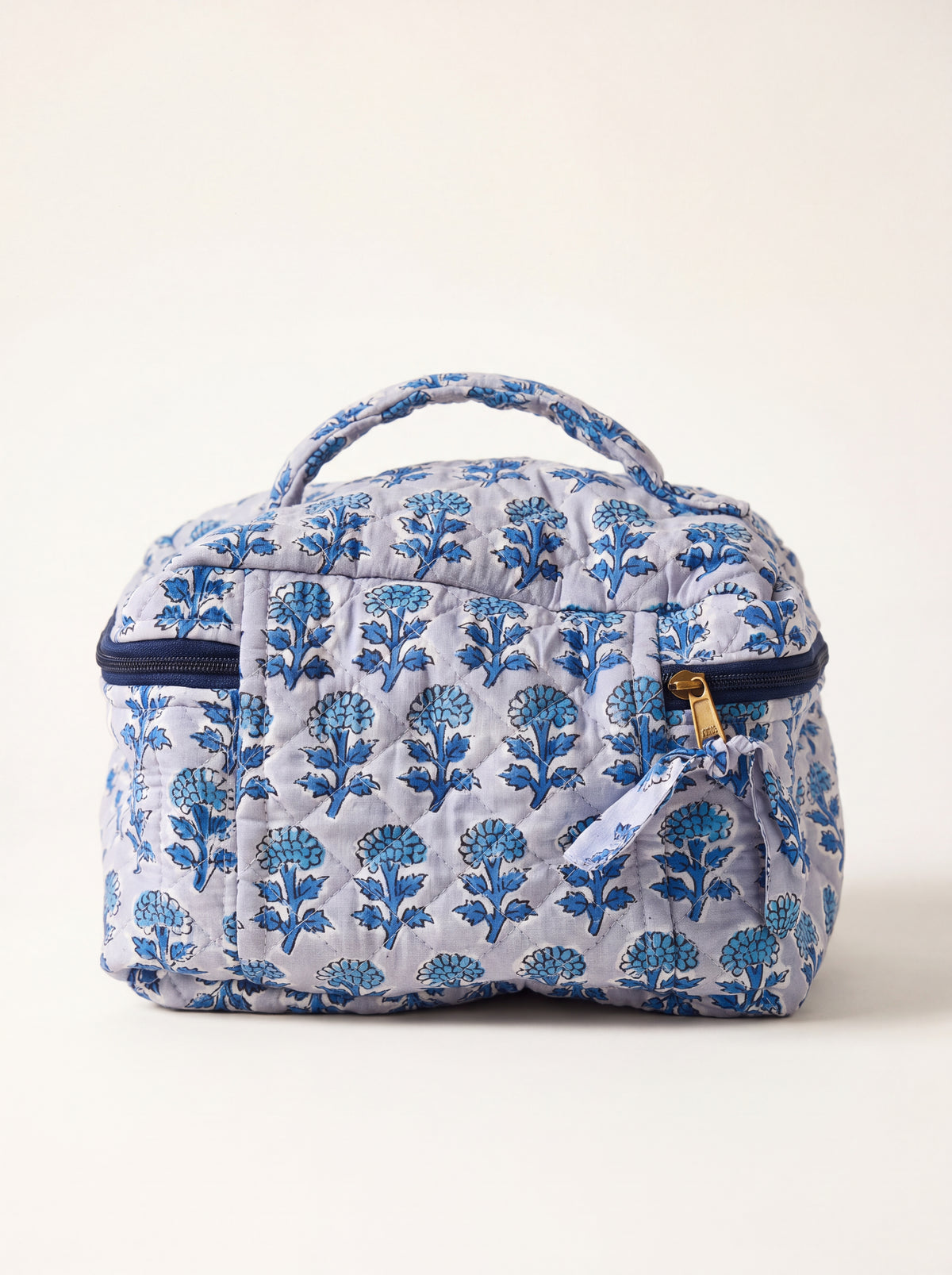 Fabalore Indigo Bloom quilted toiletry case with top carry handle and blue floral print.