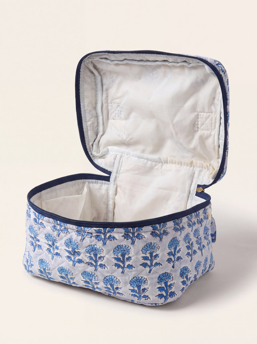 Open Fabalore Indigo Bloom quilted vanity case showing lined interior and organizational pockets.