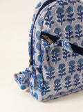 Close up of Fabalore Indigo quilted cotton backpack showing the blue floral print, front zipper pocket and fabric tie detail.