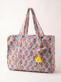Fabalore Marigold Bloom quilted tote bag with light blue floral print, exterior pockets, shoulder straps and yellow tassel.