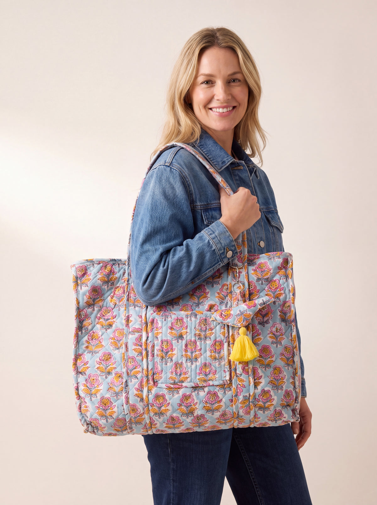 Woman carrying the Fabalore Marigold Bloom quilted tote over her shoulder, showing the large everyday size and floral print.