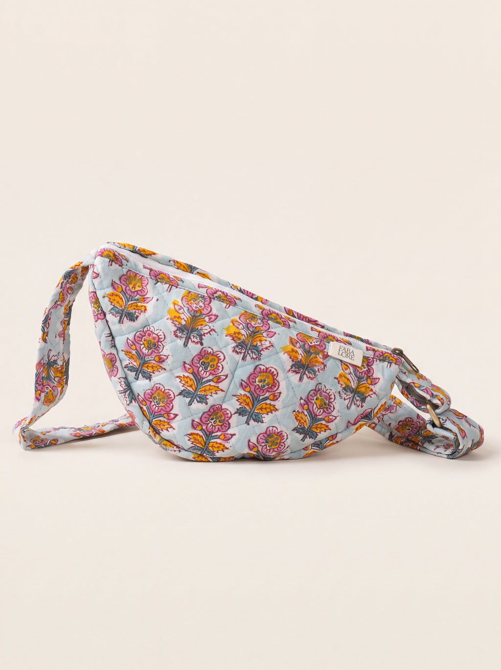 Fabalore Marigold Bloom quilted floral sling bag in light blue with pink and golden flowers.