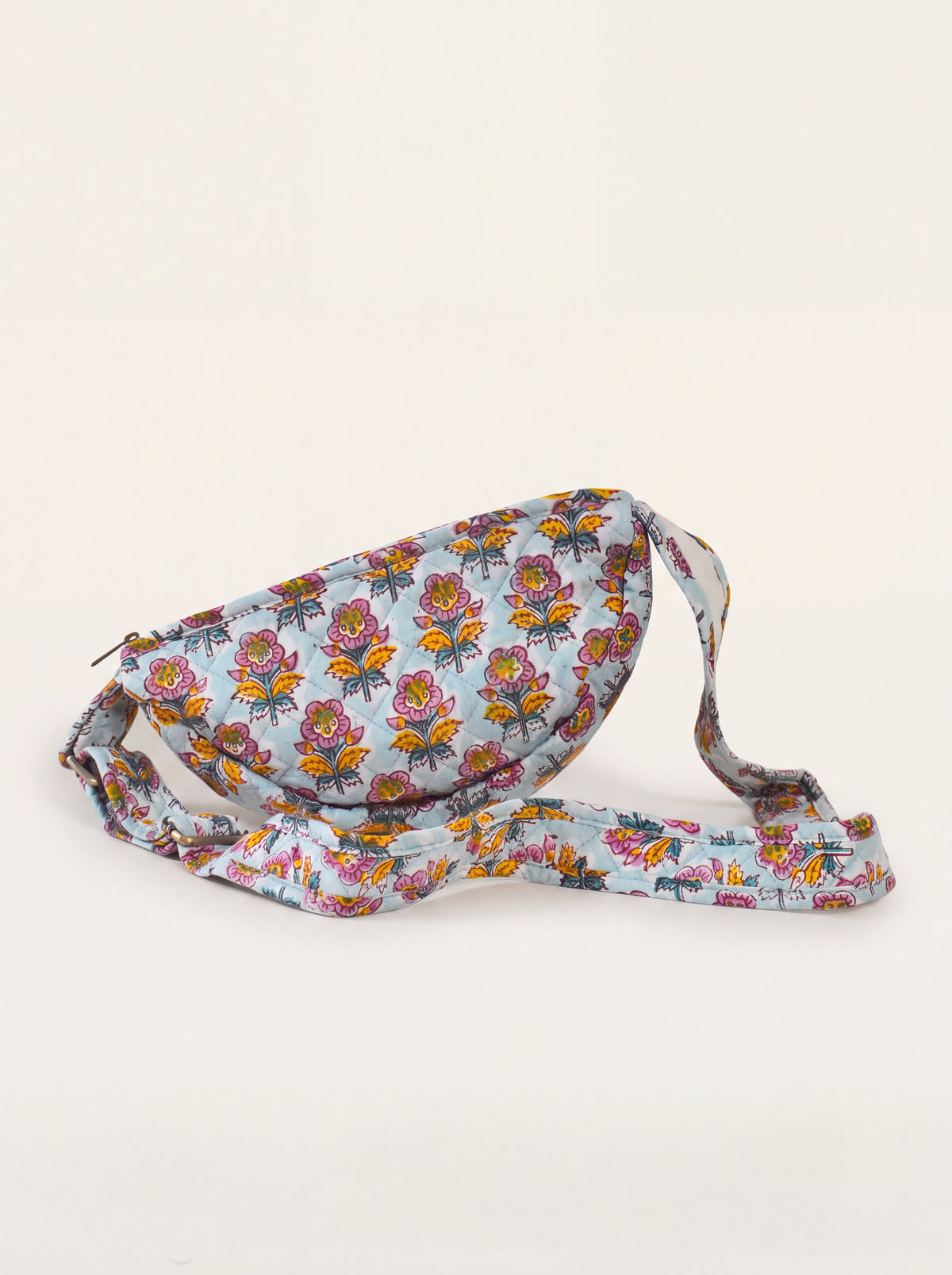 Marigold Bloom floral quilted sling bag showing curved shape and adjustable printed strap.