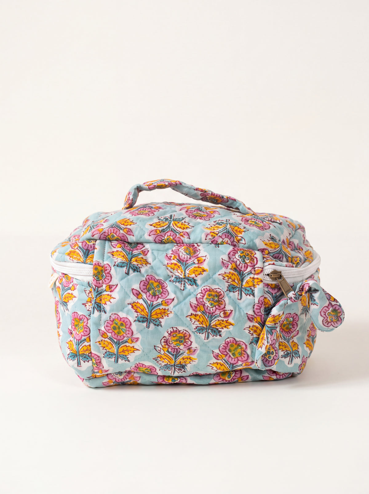 Fabalore Marigold Bloom quilted toiletry case with light blue floral print and top carry handle.