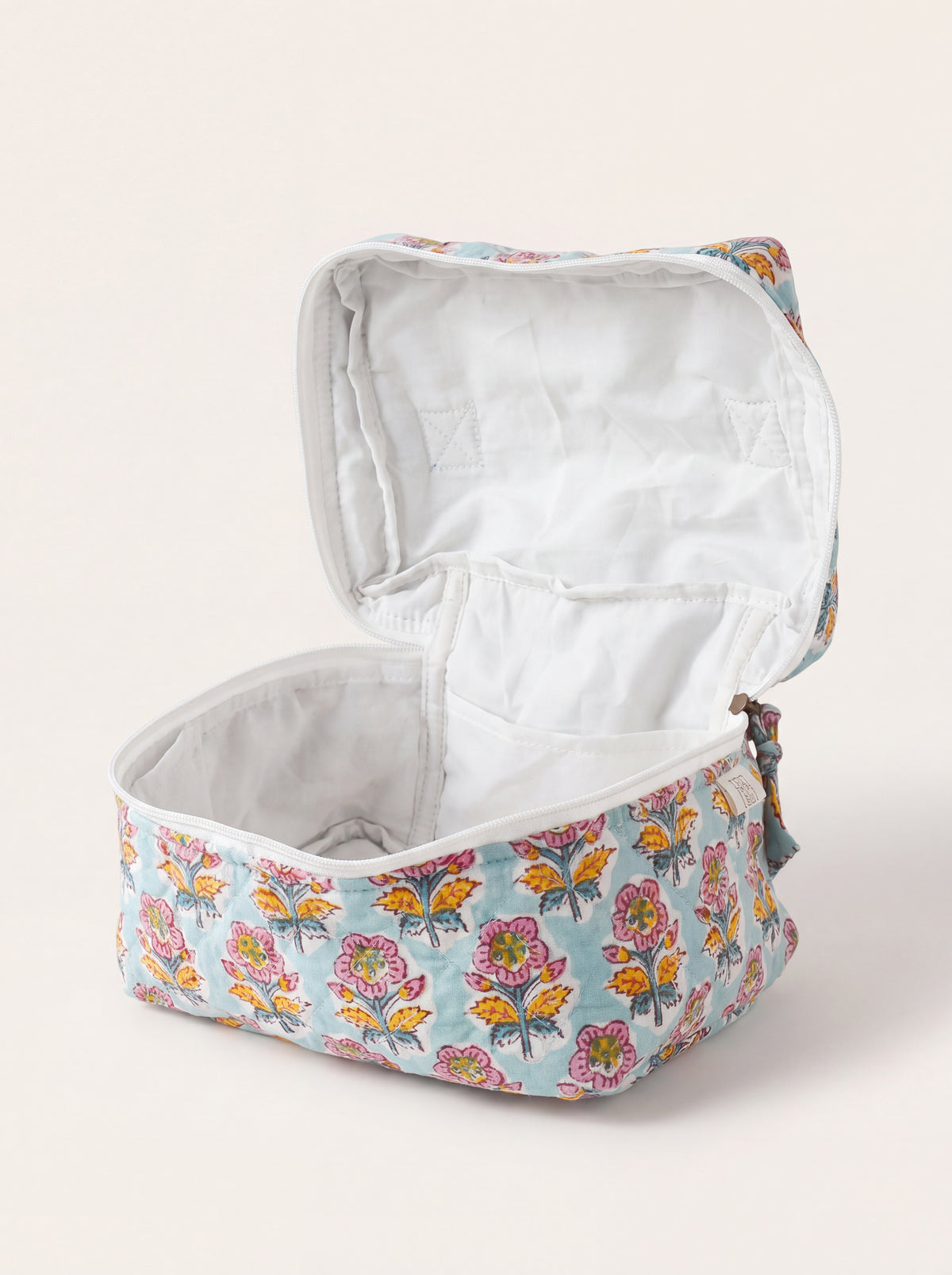 Open Fabalore Marigold Bloom quilted vanity case showing lined interior and organizational pockets.