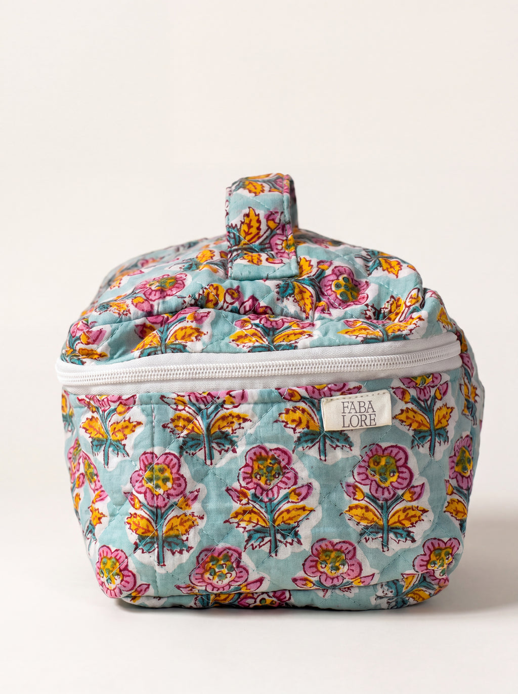 Marigold Bloom quilted floral vanity case showing structured shape, top handle and zip-around closure.
