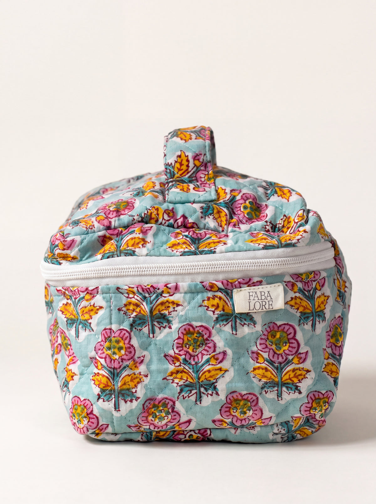 Marigold Bloom quilted floral vanity case showing structured shape, top handle and zip-around closure.