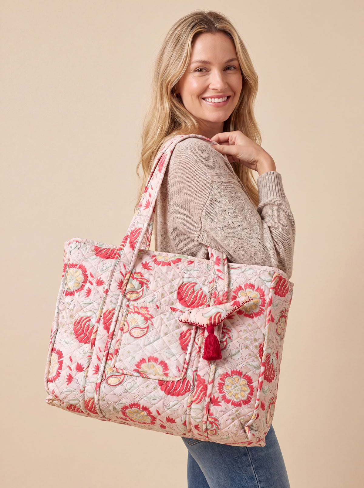 Woman carrying the large Fabalore Meadow quilted tote over her shoulder, showing its 18-inch size and floral print.