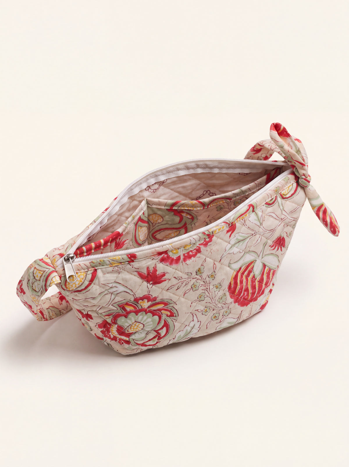 Open quilted floral sling bag showing zip closure, lined interior and inside pocket.