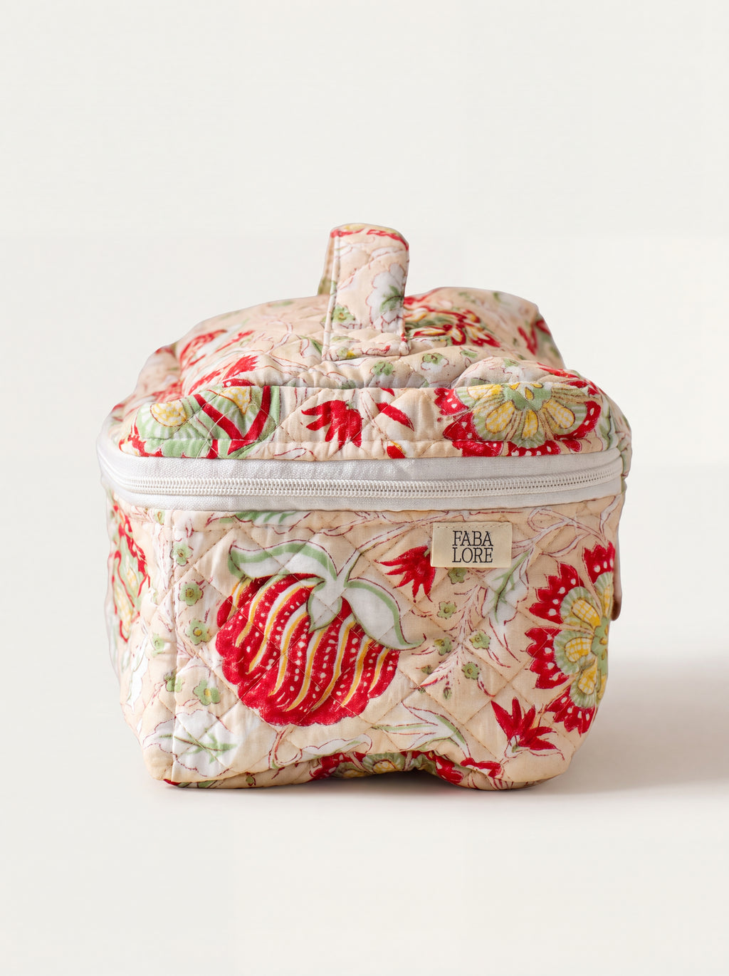 Meadow quilted floral vanity case showing structured shape, top handle and zip-around closure.