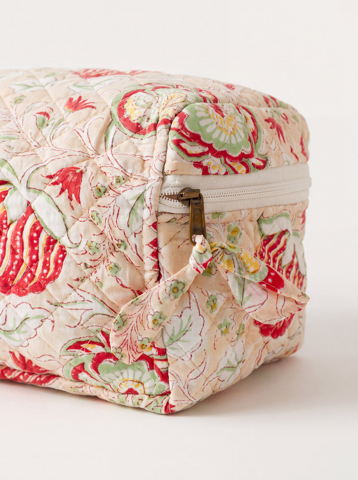 Close-up of Meadow quilted vanity case showing floral fabric, zipper and fabric zipper pull.