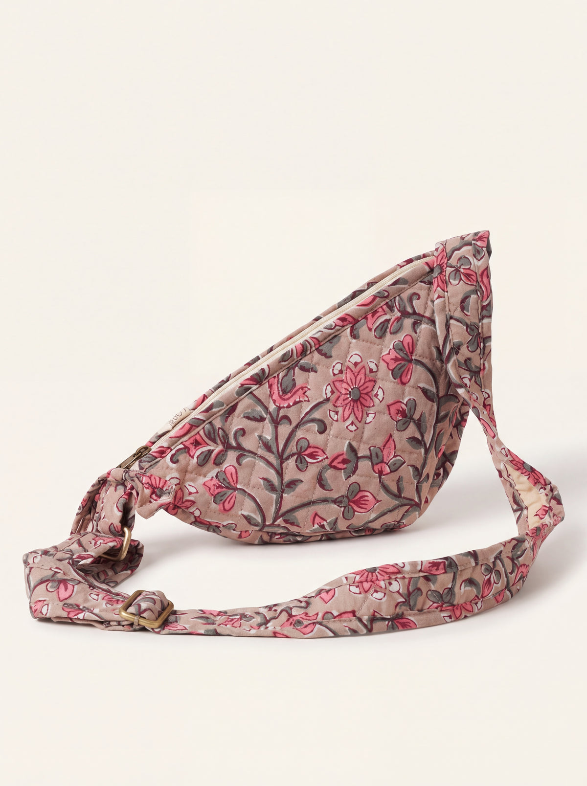 Rosewood floral quilted sling bag showing curved shape and adjustable printed strap.