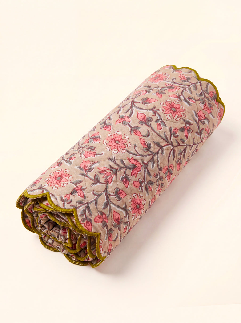 Rosewood quilted cotton table runner folded with pink floral vines and olive scalloped edge