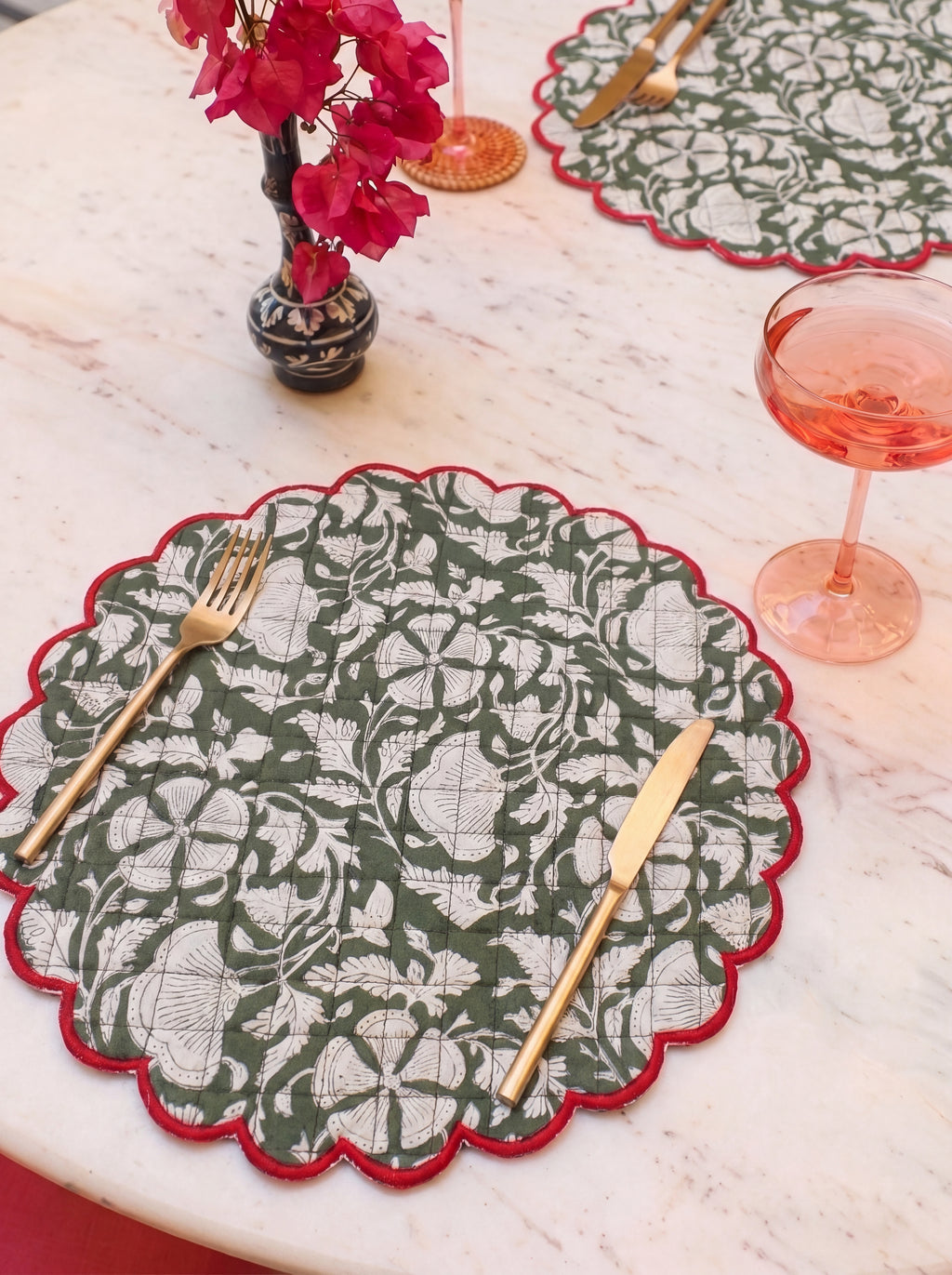 Woodland Vine scalloped botanical placemats styled with gold flatware on a dining table