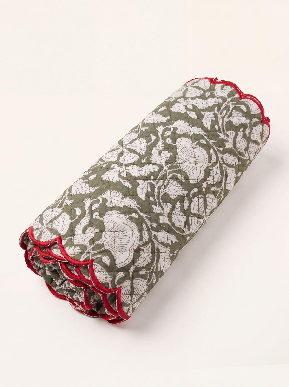 Woodland Vine olive green quilted cotton table runner folded with cream botanical print and red scalloped edge